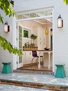 white brick house with open french doors leading to the patio