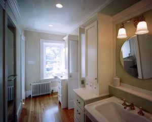 white bathroom with a double vanity and light wood floors