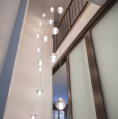 The three-story space adjacent to the elevator remaining after the stair was removed provides an open shaft where 18 glass pendants are suspended from the ceiling. The pendants provide illumination and visual interest to the unique interior space.