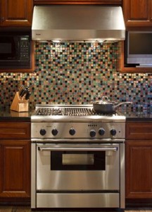 modern stainless steel gas stove with multi-colored backsplash