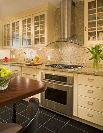 updated kitchen by Wentworth with white cabinets and tan and black countertops