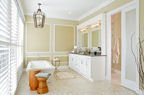 master bathroom with double vanity and standing tub