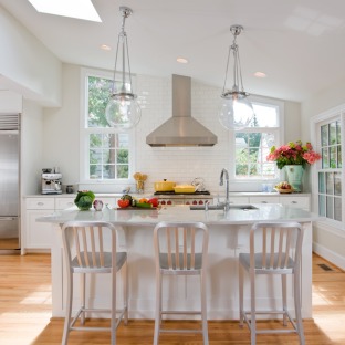 Modern kitchen with kitchen island, pendant lighting and ceiling mounted vent hood