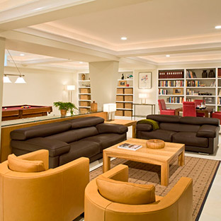 living room areal with two chocolate brown couches and tan accent chairs