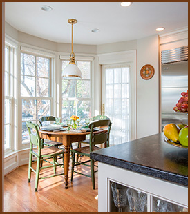 kitchen with a chestnut brown table and green chairs 