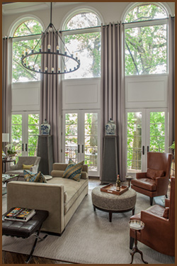 living room with high ceilings and large windows with curtains