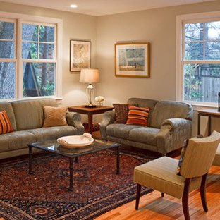 Living room with san colored couches and large area rug