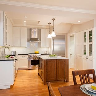 updated white kitchen and a light natural wood island