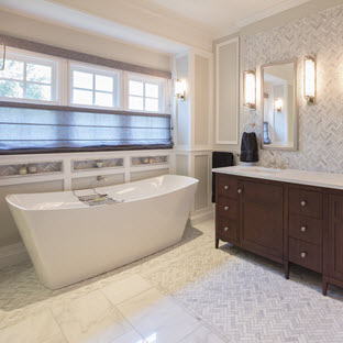 cool toned bathroom with stand-alone and grey herringbone tile and backsplash