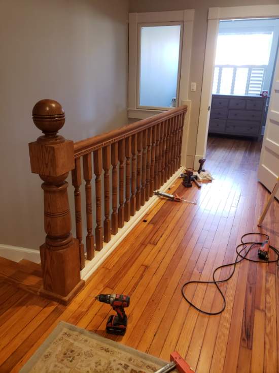 a room with hard wood floors and a railing