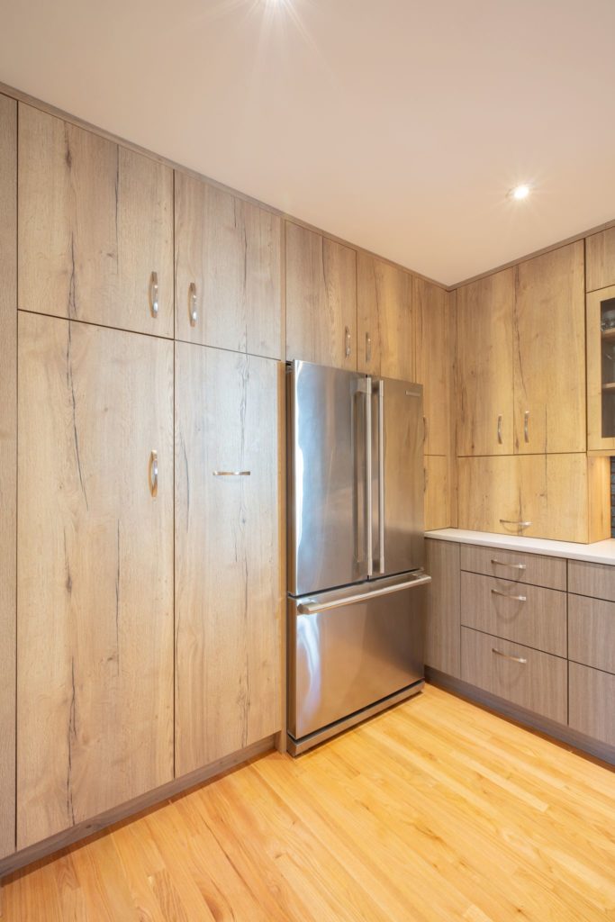 kitchen with light wood floor to ceiling cabinets