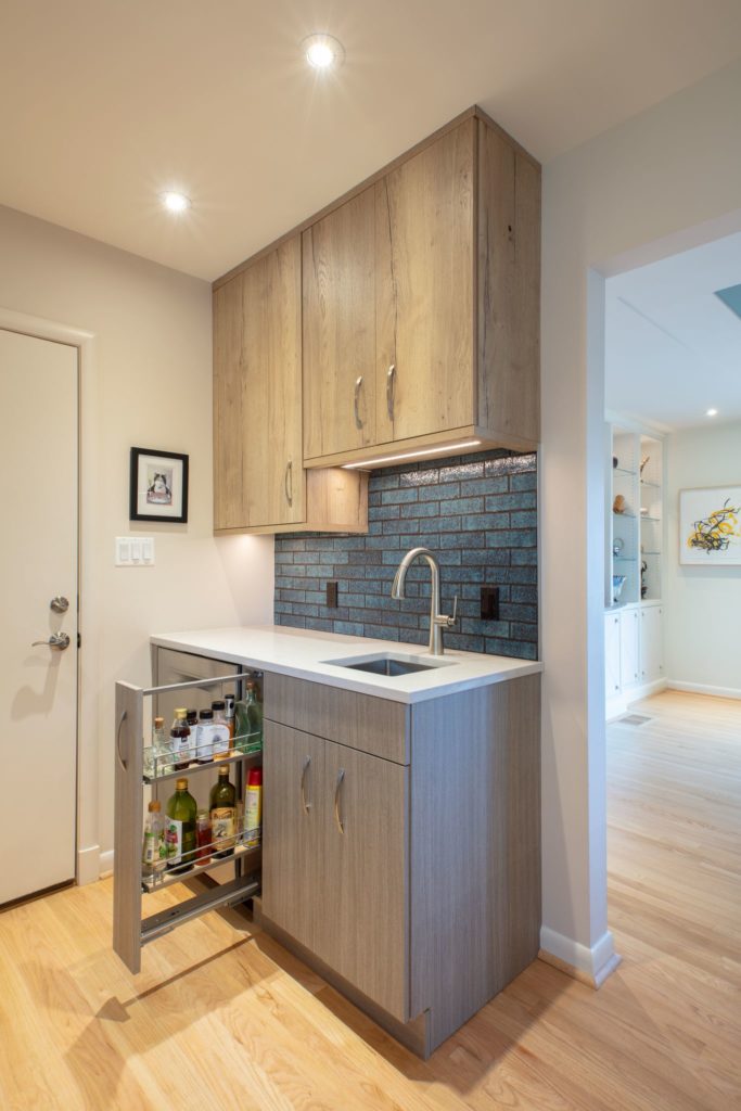 kitchen bar with light wood cabinets and a slide out oil drawer