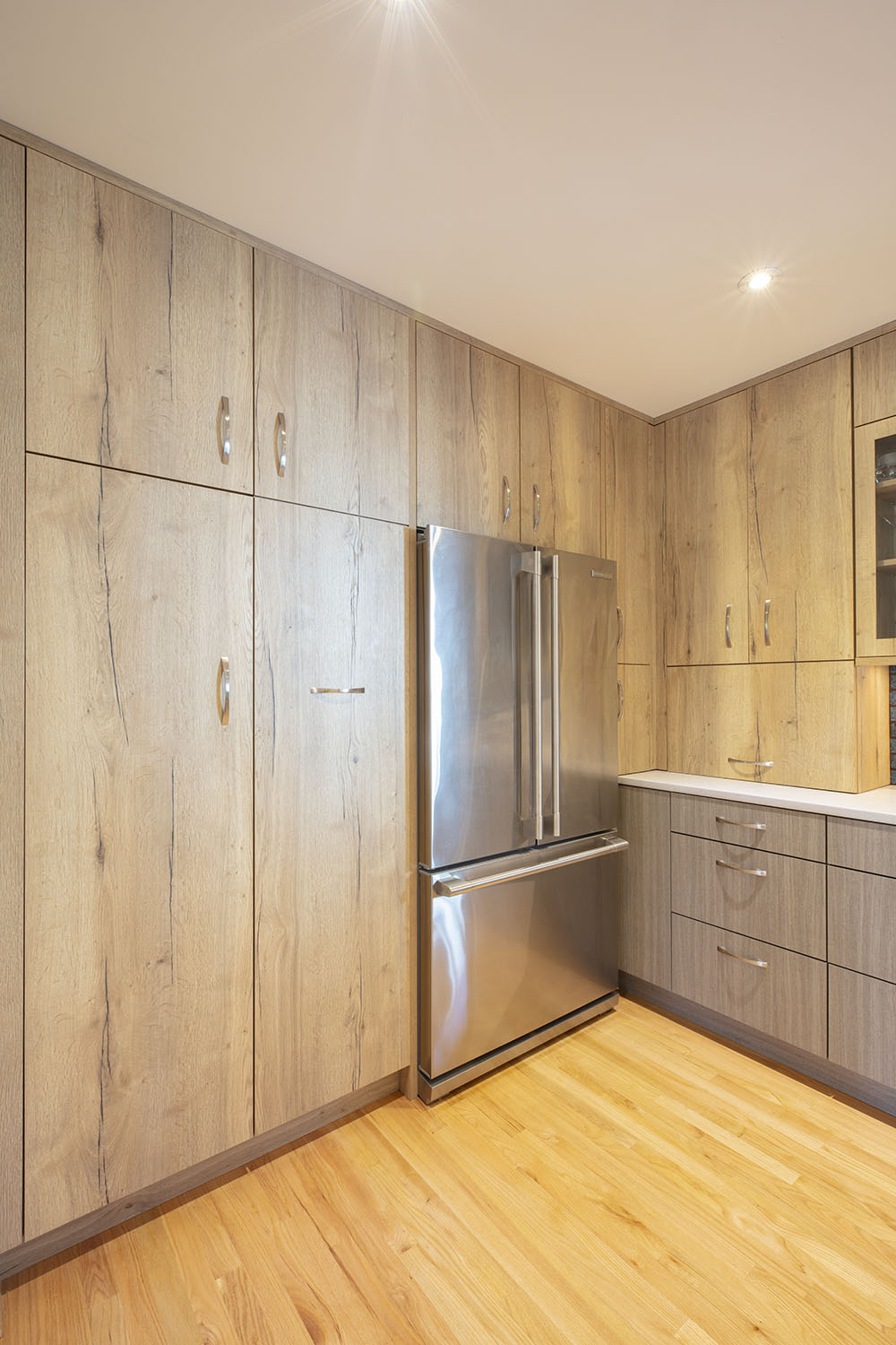 a stainless steel refrigerator surrounded by wood kitchen cabinets